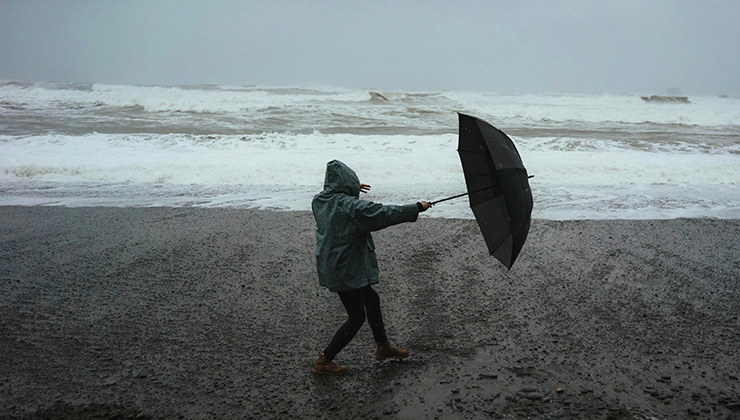 woman with umbrella on a windy beach woman with umbrella on a windy beach